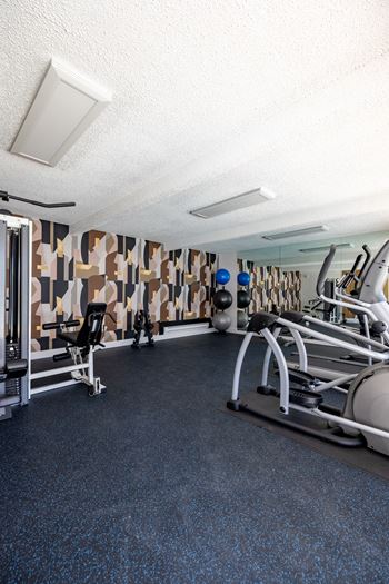 A gym with weights and other equipment on the floor